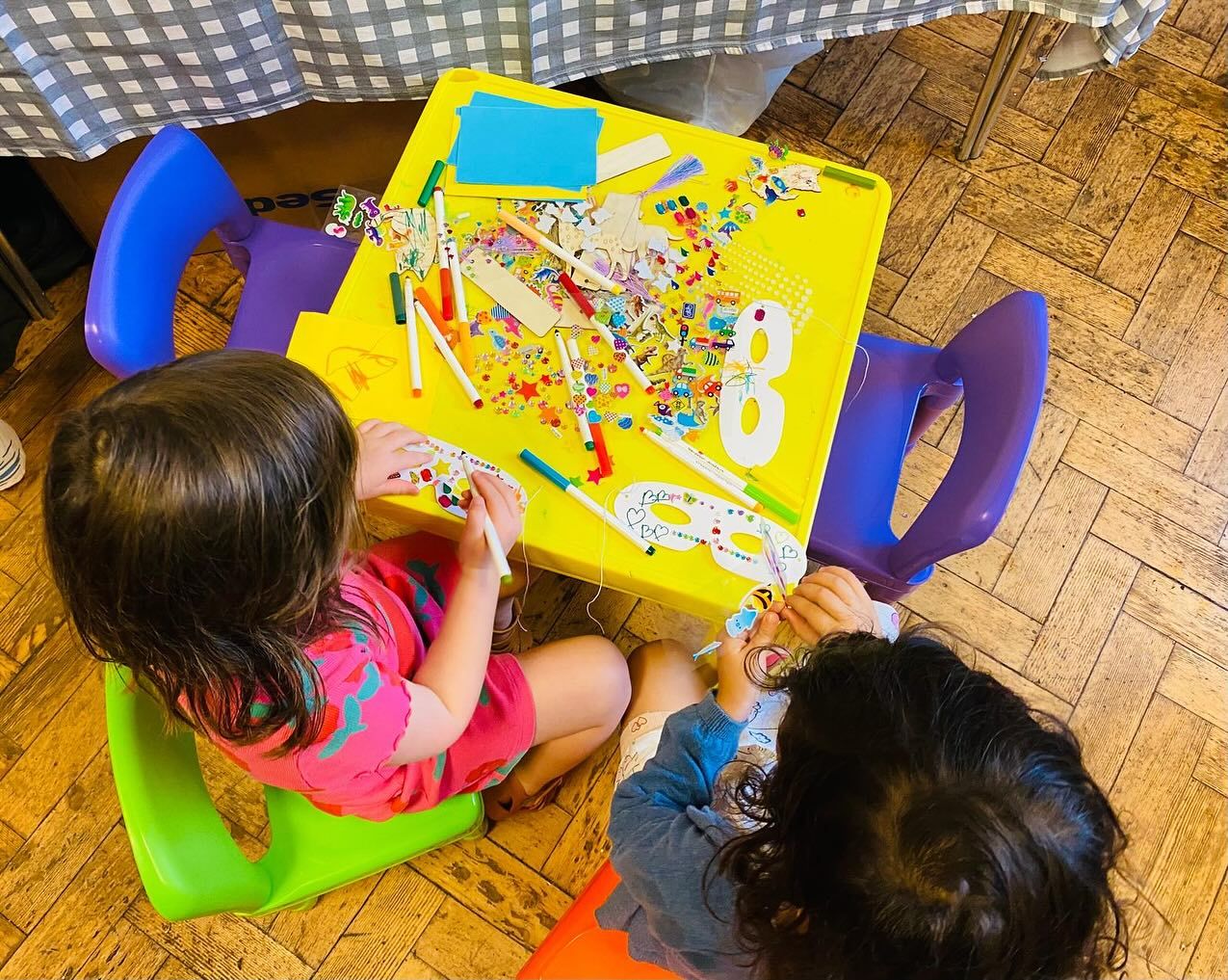 Young children drawing and playing with colourful craft materials