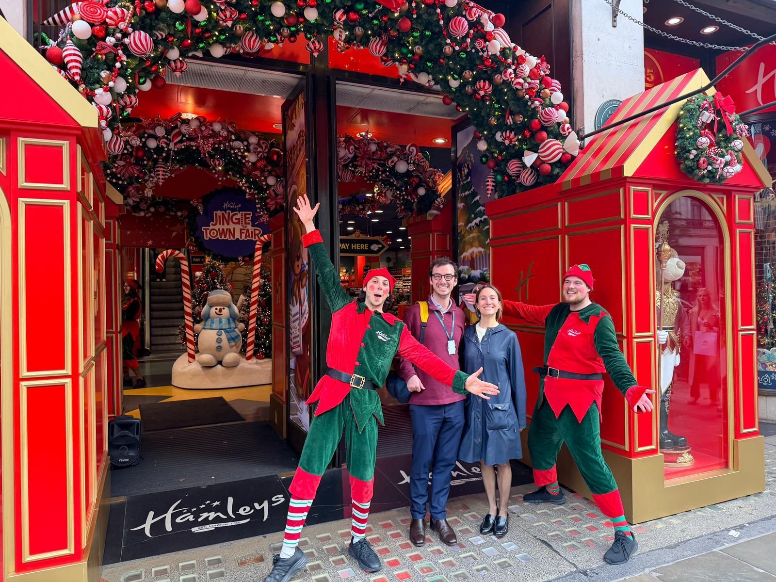 Volunteers dressed as festive elves outside a toy shop collecting gifts